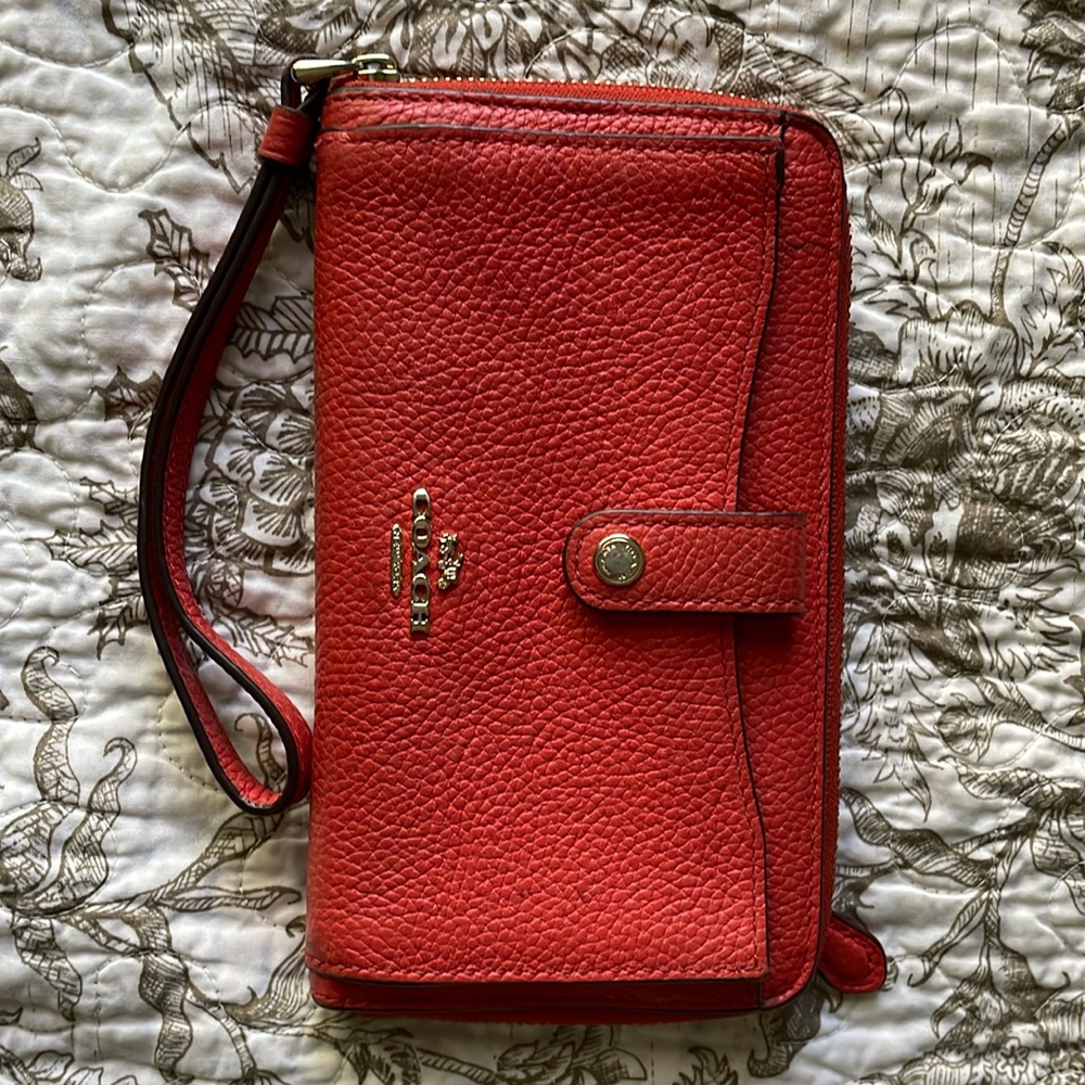 A beautiful rich coral colored Coach wristlet